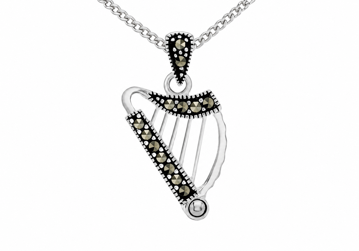 A silver harp-shaped pendant necklace embellished with small dark gemstones, hanging from a silver chain against a plain white background.
