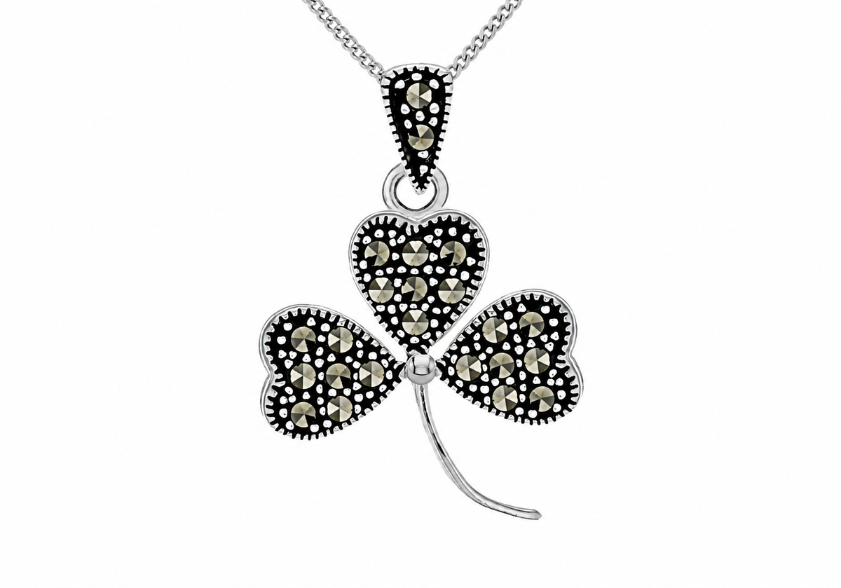 A silver-toned shamrock pendant necklace embellished with small black and champagne-colored stones, shown on a white background.