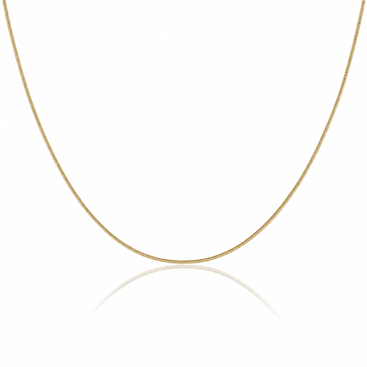 A delicate yellow gold chain necklace forming a U-shape against a clean white background with a soft reflection below.