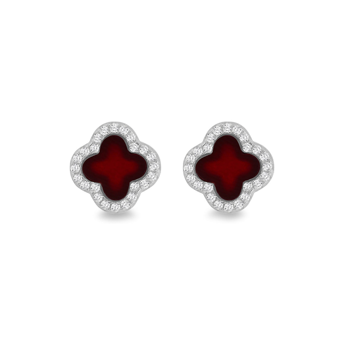 A pair of clover-shaped stud earrings featuring deep red enamel centers surrounded by a border of small clear stones in a silver-tone setting, shown on a plain white background